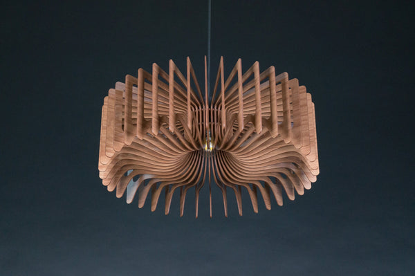 May include: A circular pendant light fixture constructed from numerous thin, curved wooden slats arranged in a radial pattern. The light features a central brass-colored socket and is suspended by a single thin cord, creating a layered, fan-like structure.